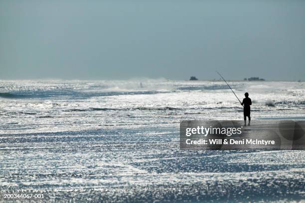 silhouette of man fishing in surf - ocracoke island stock pictures, royalty-free photos & images