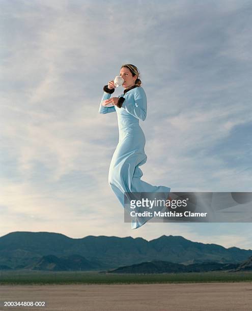woman having coffee in mid air, side view - flotando en el aire fotografías e imágenes de stock