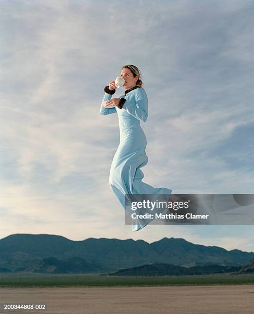 woman having coffee in mid air, side view - flutuando no ar - fotografias e filmes do acervo