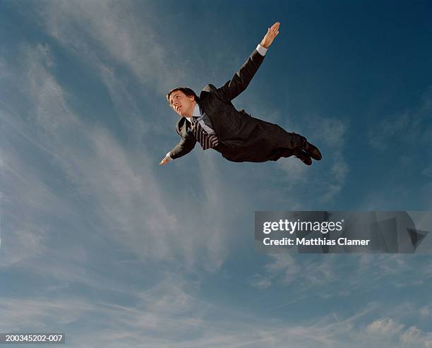 young businessman flying through sky, side view - fallen heroes stock pictures, royalty-free photos & images