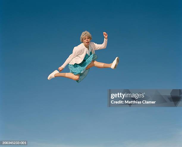 senior woman leaping in mid air, portrait - surreal sky stock pictures, royalty-free photos & images