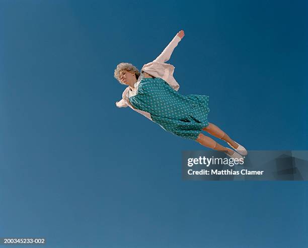 senior woman flying through sky, low angle view - young at heart fotografías e imágenes de stock