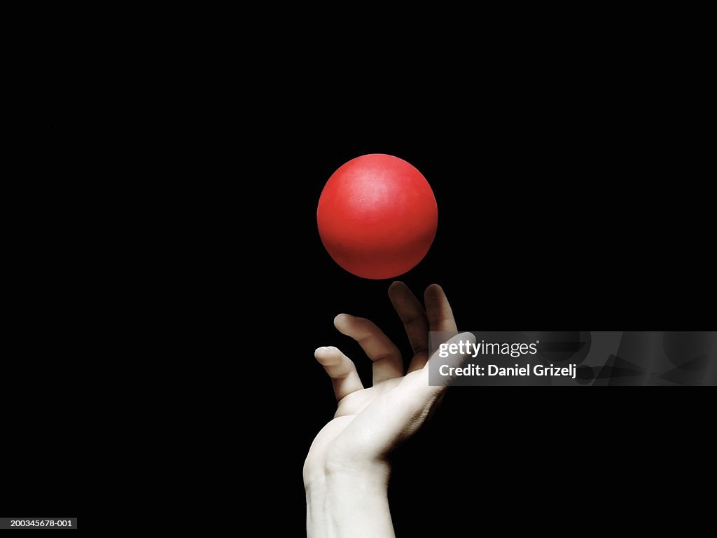 Red ball above woman's hand, close-up