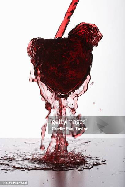red wine overflowing from glass - overflowing glass stockfoto's en -beelden