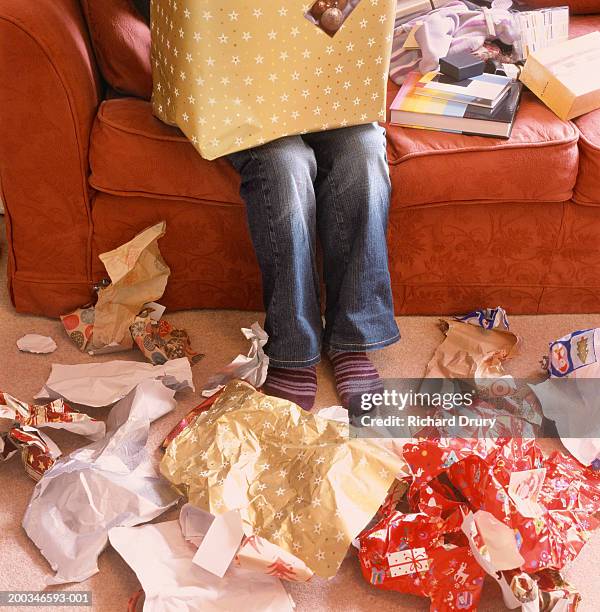 woman opening presents, wrapping paper on floor, low section - wrapping paper stock-fotos und bilder