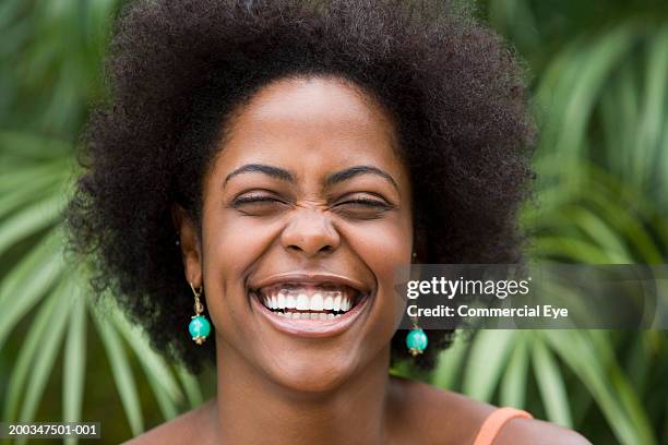 young woman laughing, eyes closed, close-up - big hair - fotografias e filmes do acervo