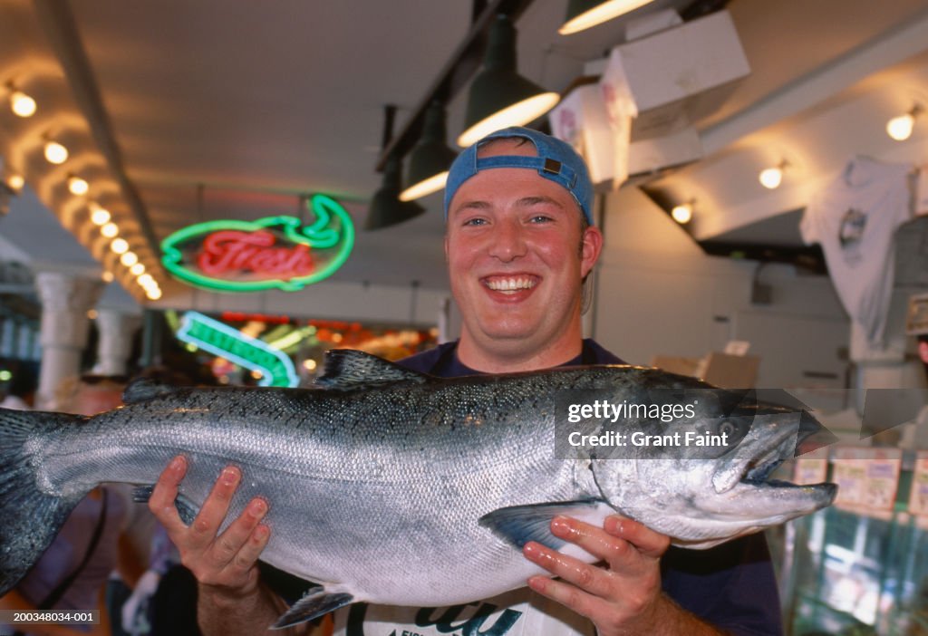 Fishmonger holding wild salmon, portait