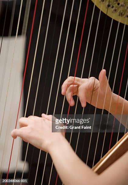 woman playing harp, close-up - arpa fotografías e imágenes de stock