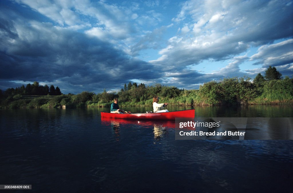 Couple in canoe, woman fishing