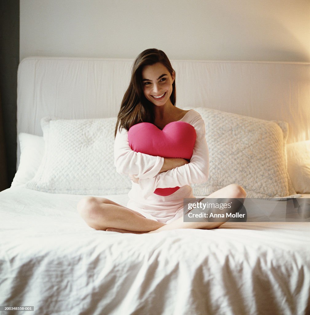 https://media.gettyimages.com/id/200348558-001/photo/young-woman-sitting-in-bed-with-heart-shaped-cushion.jpg?s=1024x1024&w=gi&k=20&c=pjmqOrGTrAYImBYtccmRsvftdPdXAcx635c-JKnwIjA=