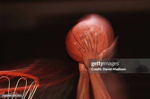 male basketball player dunking ball into basket, close-up of hands - basketball close up stock-fotos und bilder