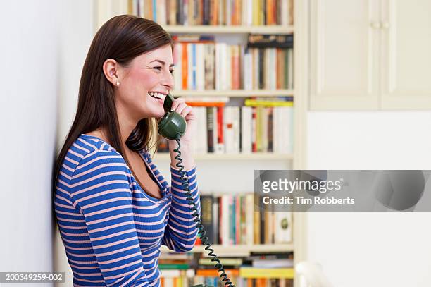 young woman on telephone at home, side view - landline phone imagens e fotografias de stock
