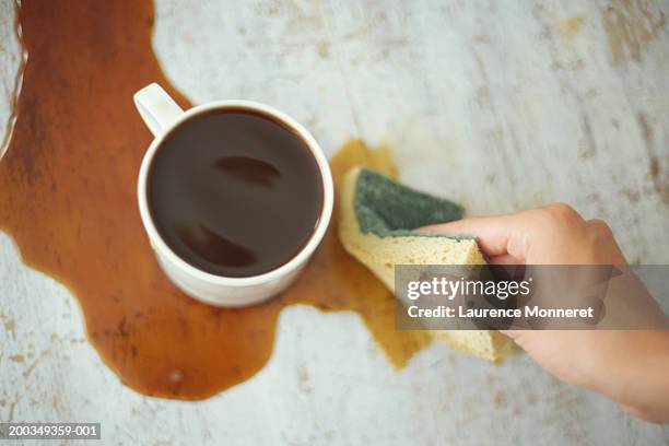 woman cleaning up coffee spill, close-up - coffee spill stock pictures, royalty-free photos & images