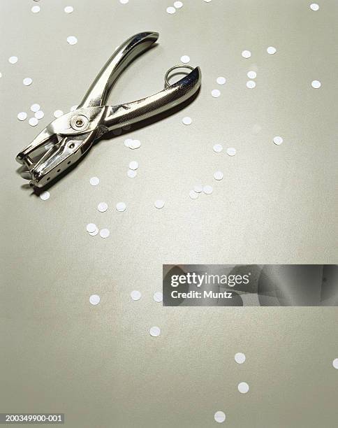 hole puncher on counter with punched out holes - hole punch stock pictures, royalty-free photos & images