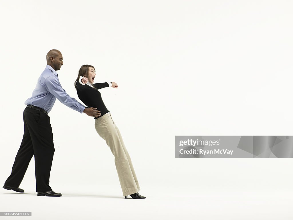 Man catching woman falling back by waist, side view