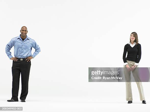 man and woman standing apart, smiling, portrait - woman standing stockfoto's en -beelden