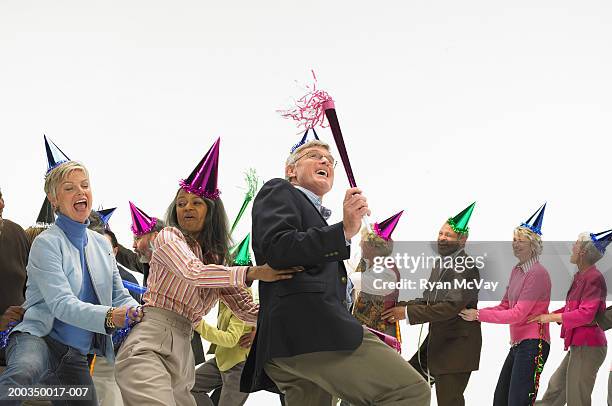 group of mature men and women with party accessories, dancing - faire la chenille photos et images de collection
