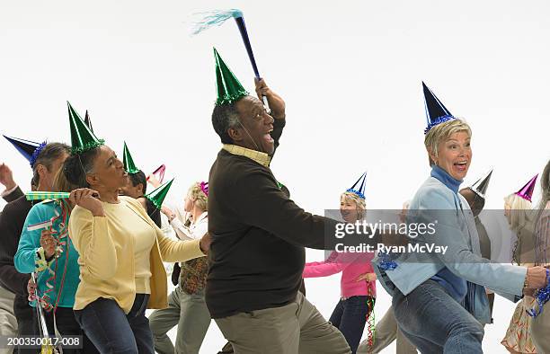 group of mature men and women with party accessories, dancing - faire la chenille photos et images de collection