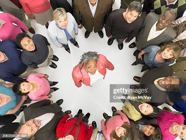 group of mature men and women standing in circle around woman - surrounding stock pictures, royalty-free photos & images