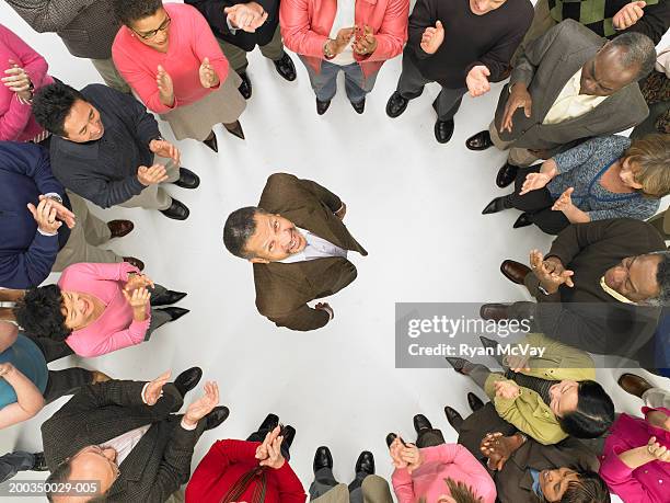 group of mature men and women standing in circle around man, clapping - surrounding support stock pictures, royalty-free photos & images