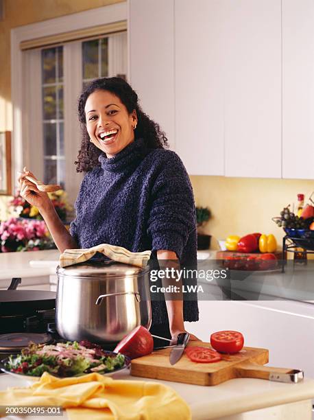woman in kitchen smiling - burner stove top stockfoto's en -beelden