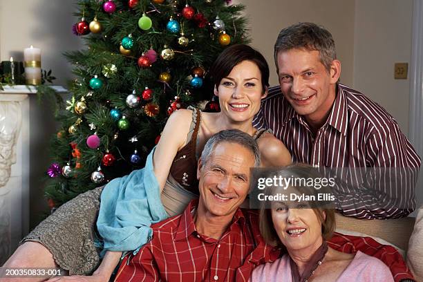 couple relaxing by christmas tree with mature couple, smiling,portrait - front view portrait of four children sitting on rock stock-fotos und bilder