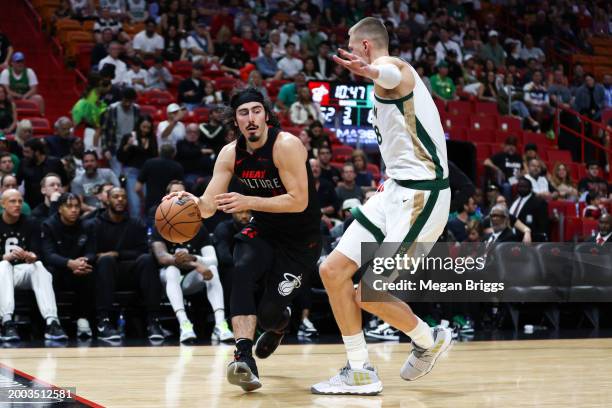 Jaime Jaquez Jr. #11 of the Miami Heat drives against Kristaps Porzingis of the Boston Celtics during the third quarter of the game at Kaseya Center...