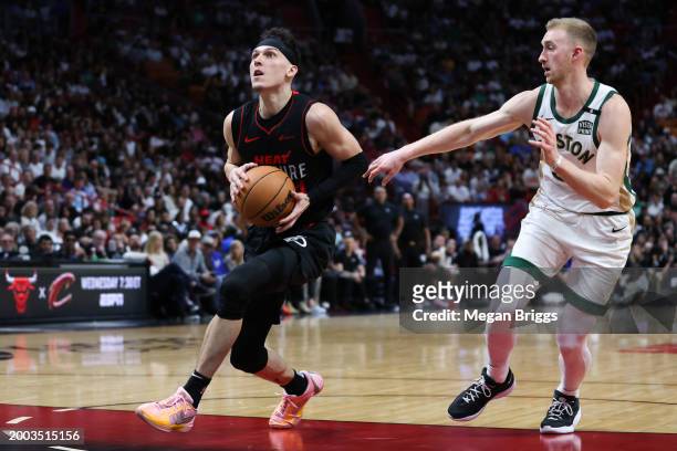 Tyler Herro of the Miami Heat drives to the basket past Sam Hauser of the Boston Celtics during the third quarter of the game at Kaseya Center on...