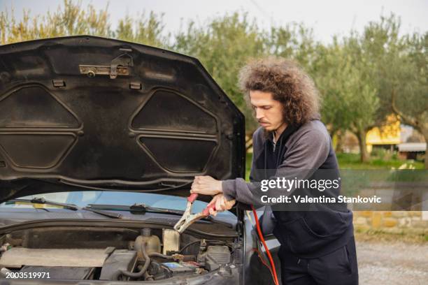 alte autos haben in der regel alte batterien, die einen kleinen kick brauchen - starthilfe stock-fotos und bilder