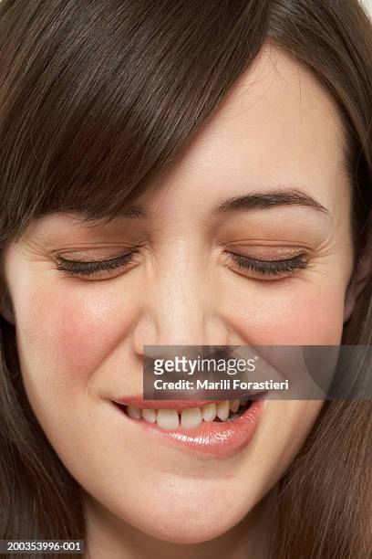 young woman biting lip, close-up - biting lip stock pictures, royalty-free photos & images