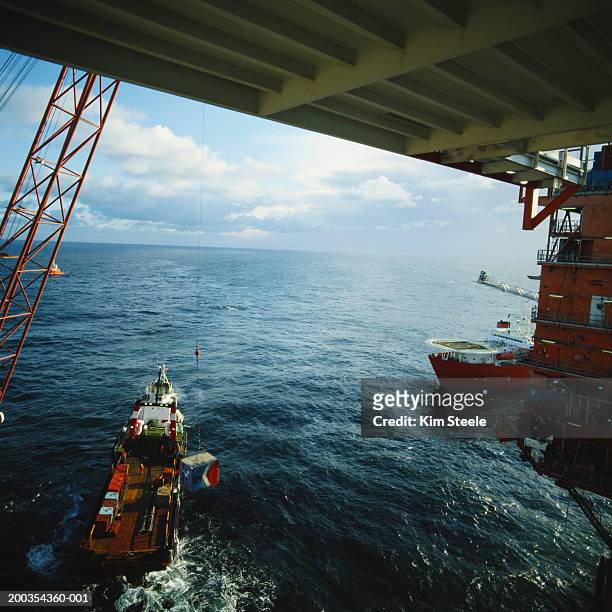 norway, north sea, crane lifting crates off service boat at oil rig - 1983 stock pictures, royalty-free photos & images