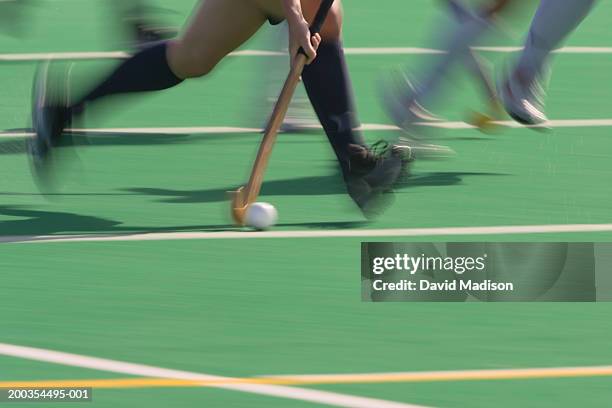 women's field hockey players in action, low section (blurred motion) - hockey equipment stockfoto's en -beelden