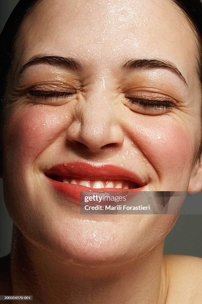 Young woman perspiring, laughing, close-up