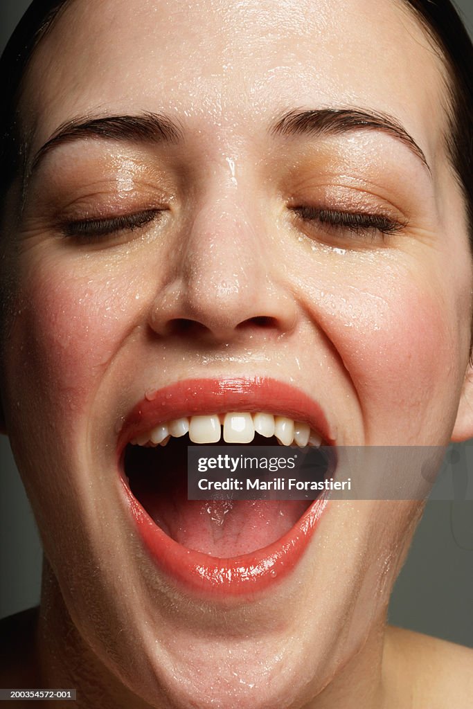 Young woman perspiring with mouth open, close-up