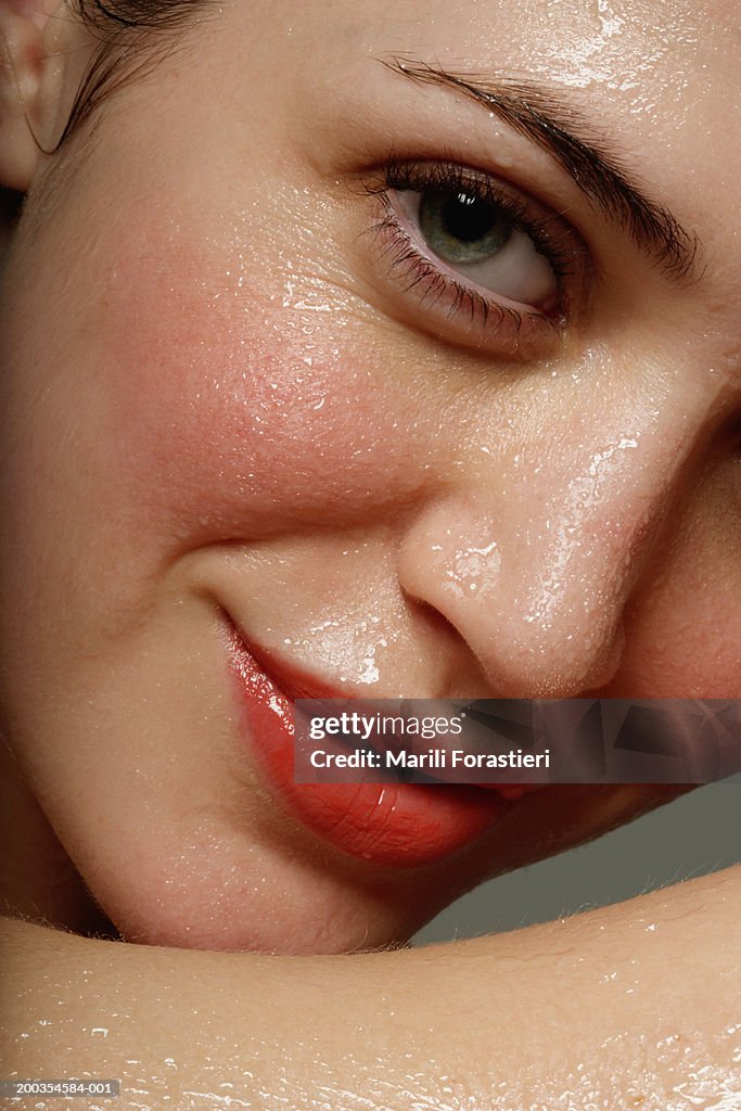 Young woman perspiring, smiling, portrait, close-up