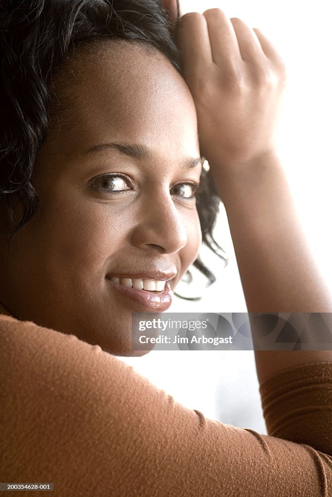 Woman resting hand on head, close-up, portrait