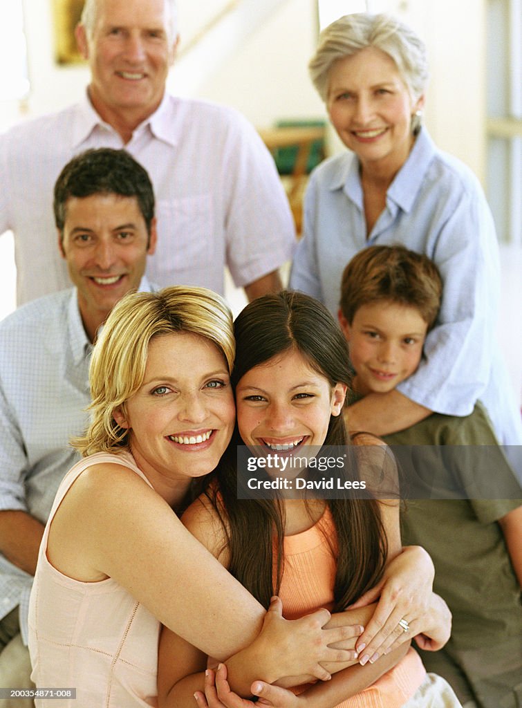 Three generational family, woman embracing daughter (9-11), portrait