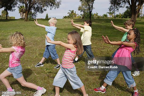 group of children (6-7 years) standing in park, arms out, side view - 7 fotografías e imágenes de stock