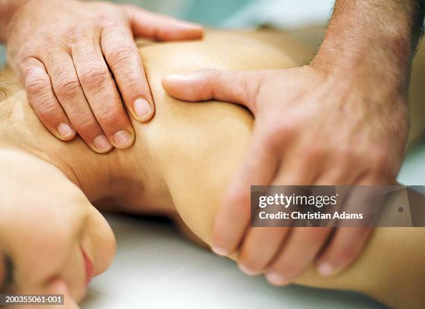 man massaging woman's neck and shoulder, close-up - massage stock pictures, royalty-free photos & images