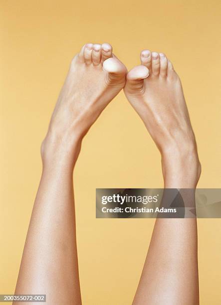 young woman rubbing big toes together, close-up - feet on table bildbanksfoton och bilder