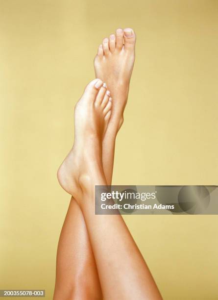 young woman with one foot resting on shin of other, close-up - legs crossed at ankle stock pictures, royalty-free photos & images