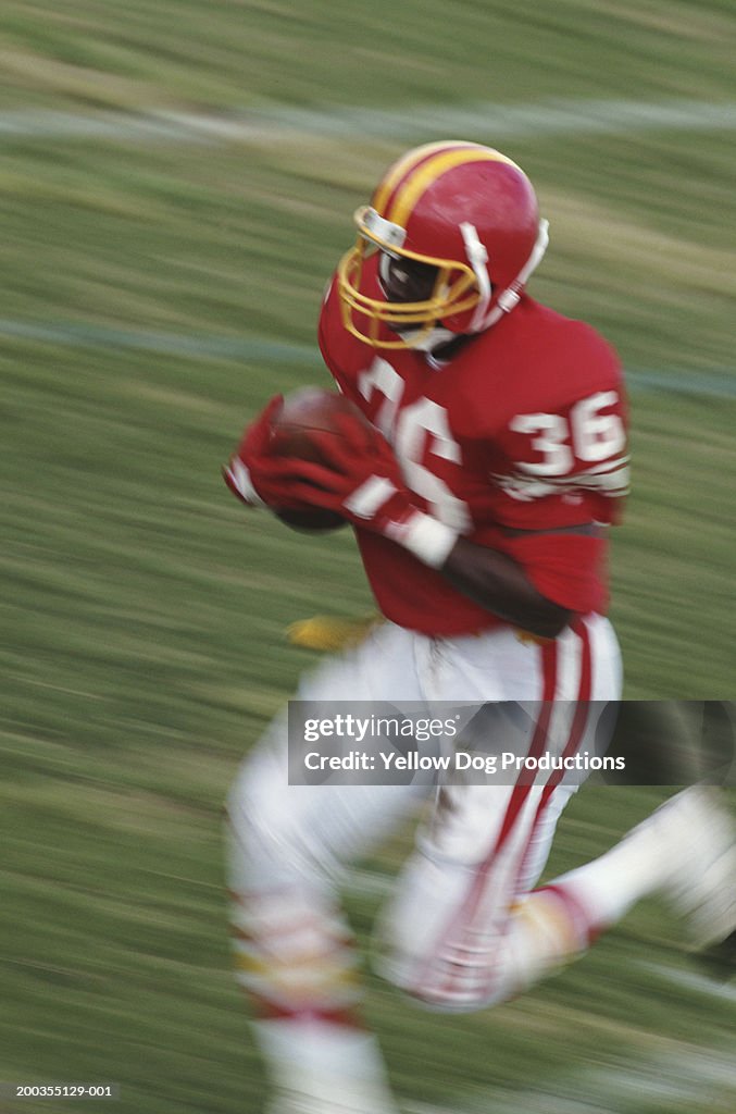 Football player running with ball (blurred motion)