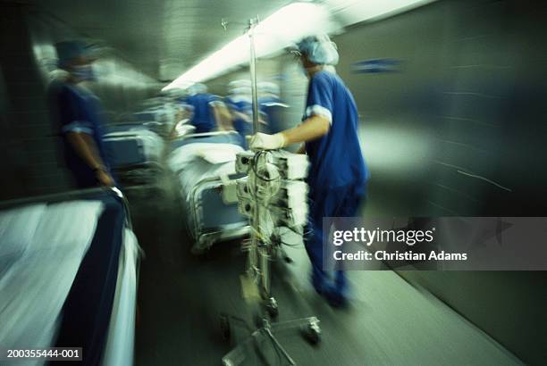 hospital staff pushing gurney and equipment in hallway(blurred motion) - stretcher stock-fotos und bilder