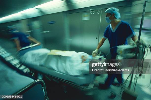 hospital staff pushing gurney and equipment in hallway(blurred motion) - hospital gurney fotografías e imágenes de stock