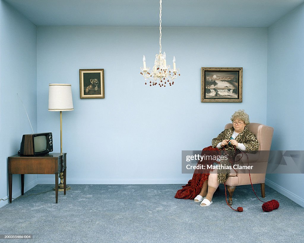 Mature woman knitting in living room