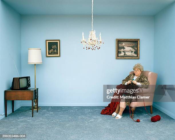 mature woman knitting in living room - knitting stock pictures, royalty-free photos & images