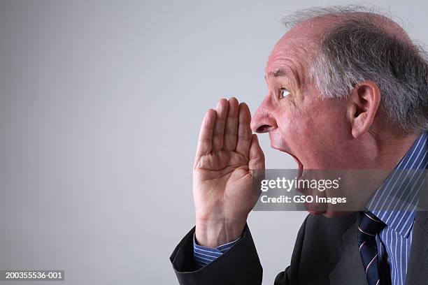 businessman shouting with hand raised to mouth, side view, close-up - mouth open profile stock pictures, royalty-free photos & images