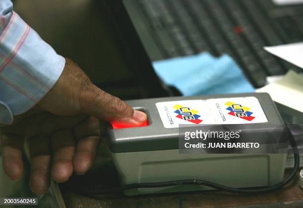 Venezuelan citizen has his fingerprint checked prior to vote in the constitutional referendum 02 December, 2007 in Caracas. Venezuelans cast ballots...