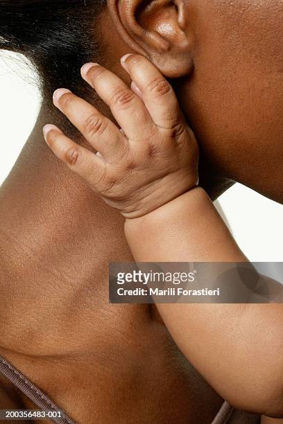 mother holding baby girl (6-9 months), side view, close-up - baby skin fotografías e imágenes de stock