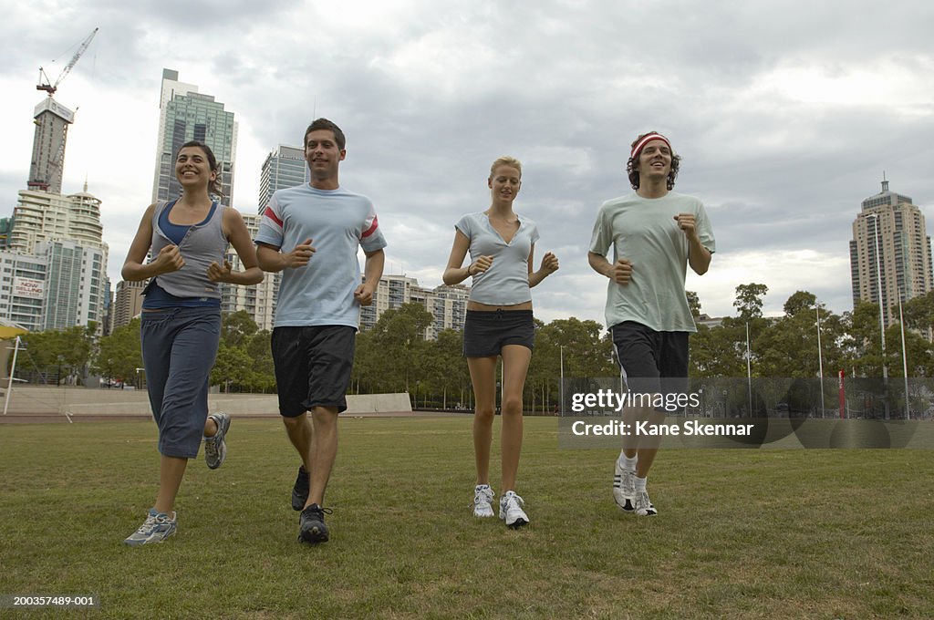Young men and women jogging in park